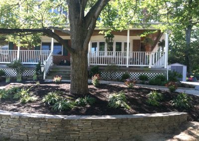 Hardscaped front exterior, stone flower bed